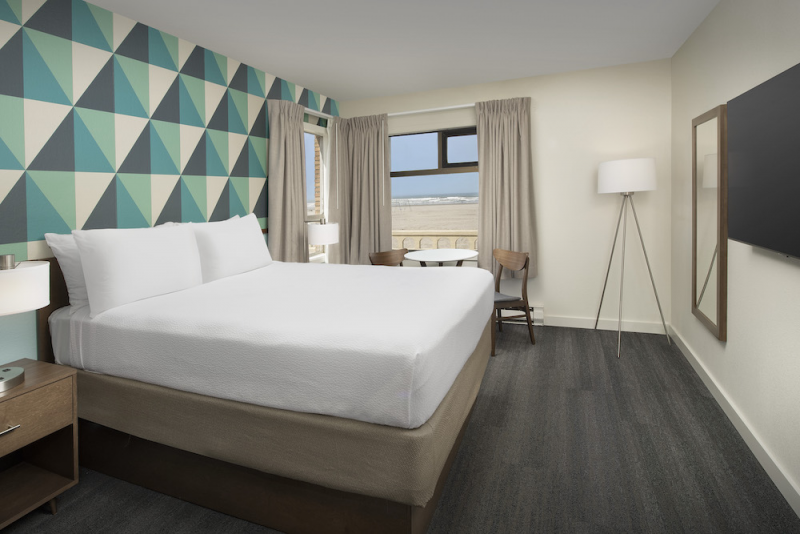 Ocean Front Hotel Corner side Queen Guestroom with bed and Dining space